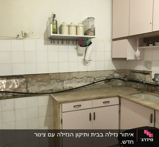 מטבח עם קיר חשוף וצנרת גלויה